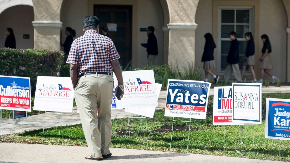 PHOTO: A voter stops to look at primary election signs outside the polling place at St. Anne's Catholic Church on Tuesday, March 6, 2018, in Houston.