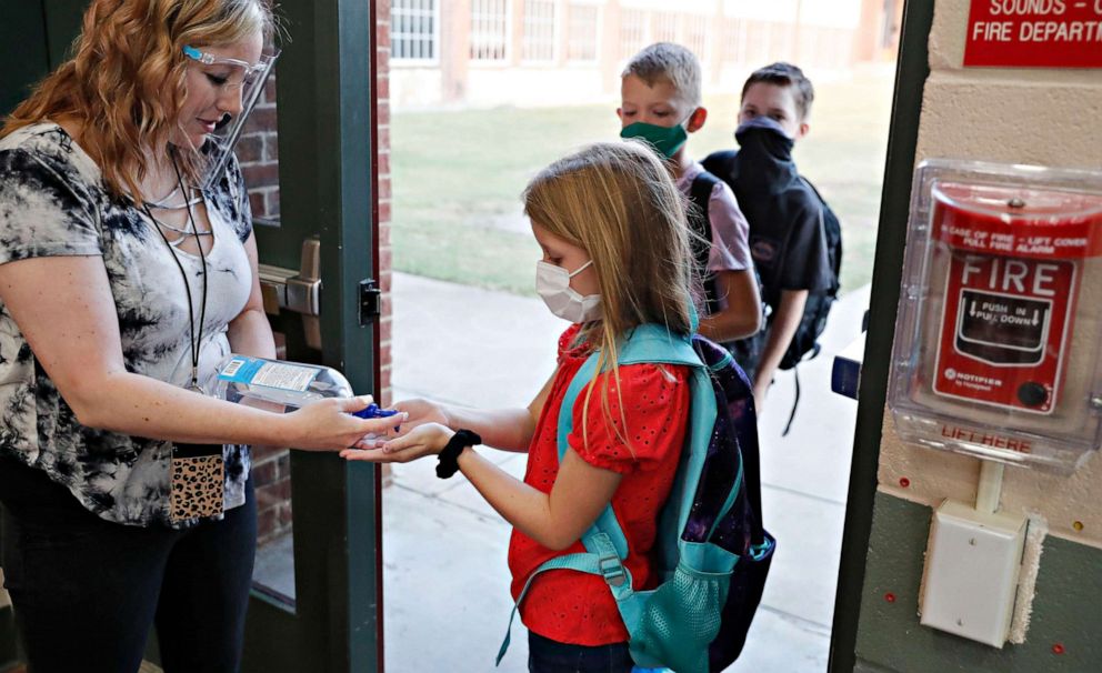 PHOTO: Elementary school students use hand sanitizer before entering school for classes in Godley, Texas, Aug. 5, 2020.