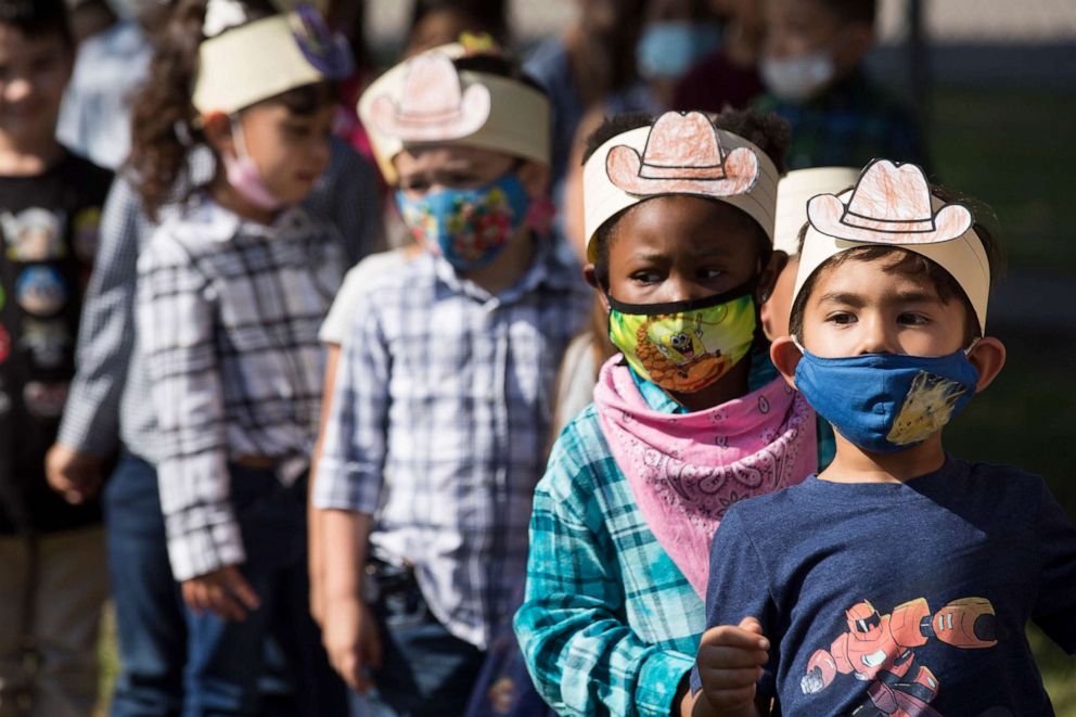 PHOTO: Atkinson Elementary School students wear paper cowboy hats as they line up to take a look at the covered wagons and horses stopping at the school during the 3rd Annual Pasadena Rodeo Round-Up Ride, Sept. 9, 2021, in Houston.