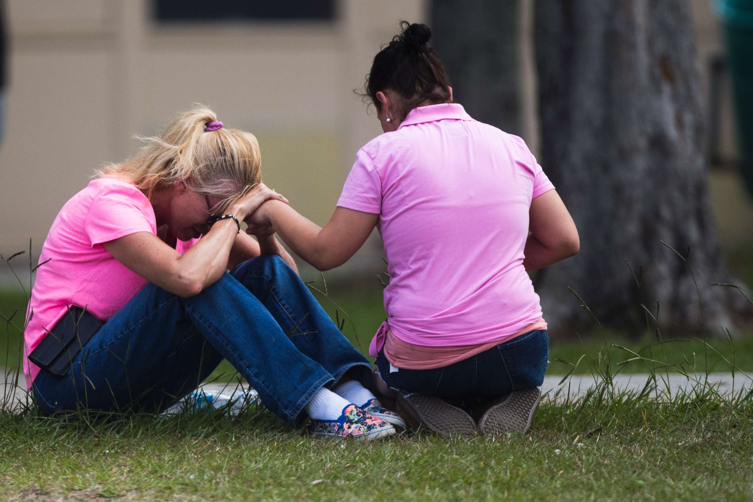 PHOTO: Two women pray outside the family reunification site following a shooting at Santa Fe High School on May 18, 2018, in Santa Fe, Texas.