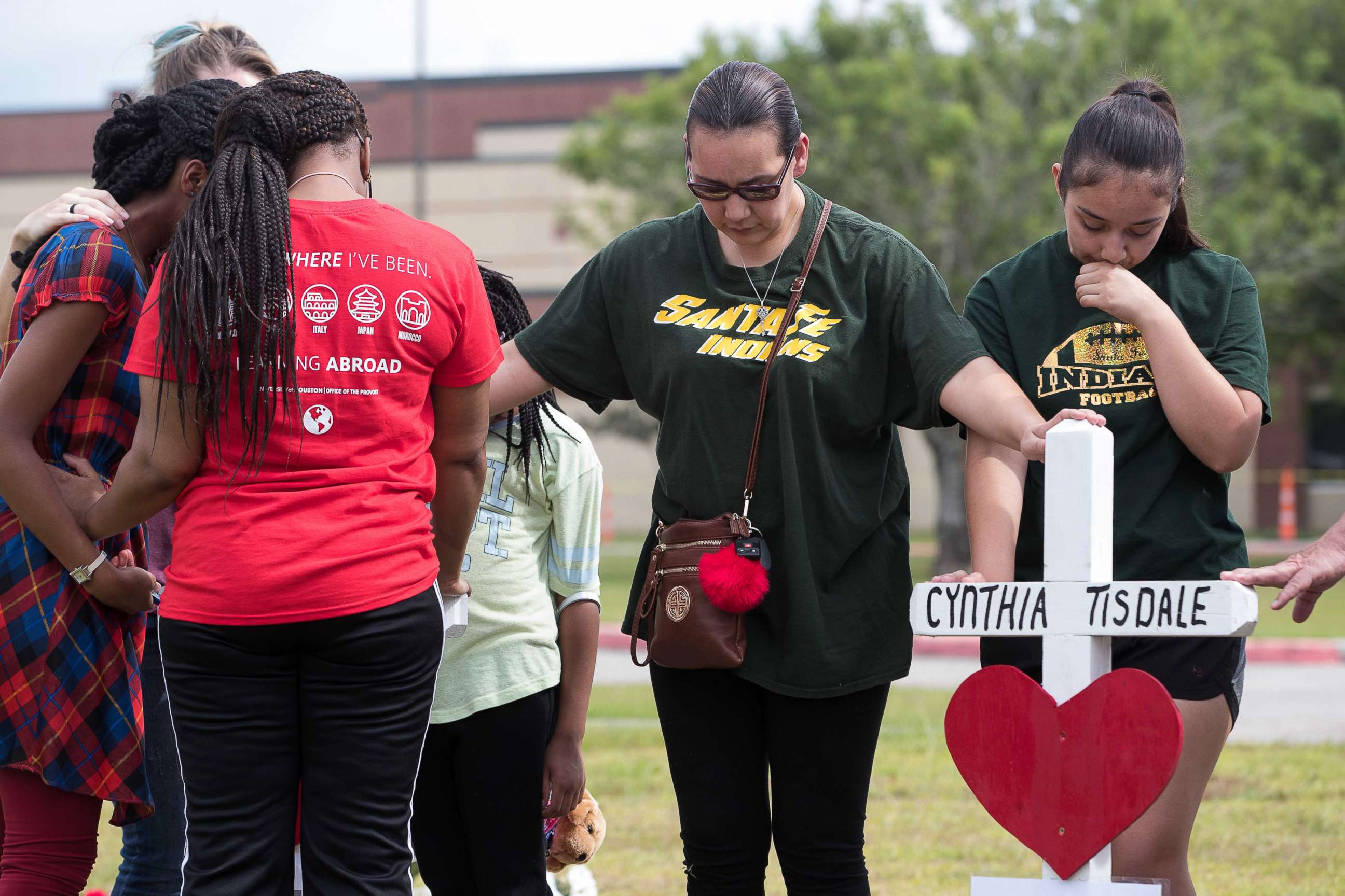 PHOTO:  People place their hands on the crosses at the makeshift memorial outside Santa Fe High School during a moment of silence at 10am, May 21, 2018, in Santa Fe, Texas.