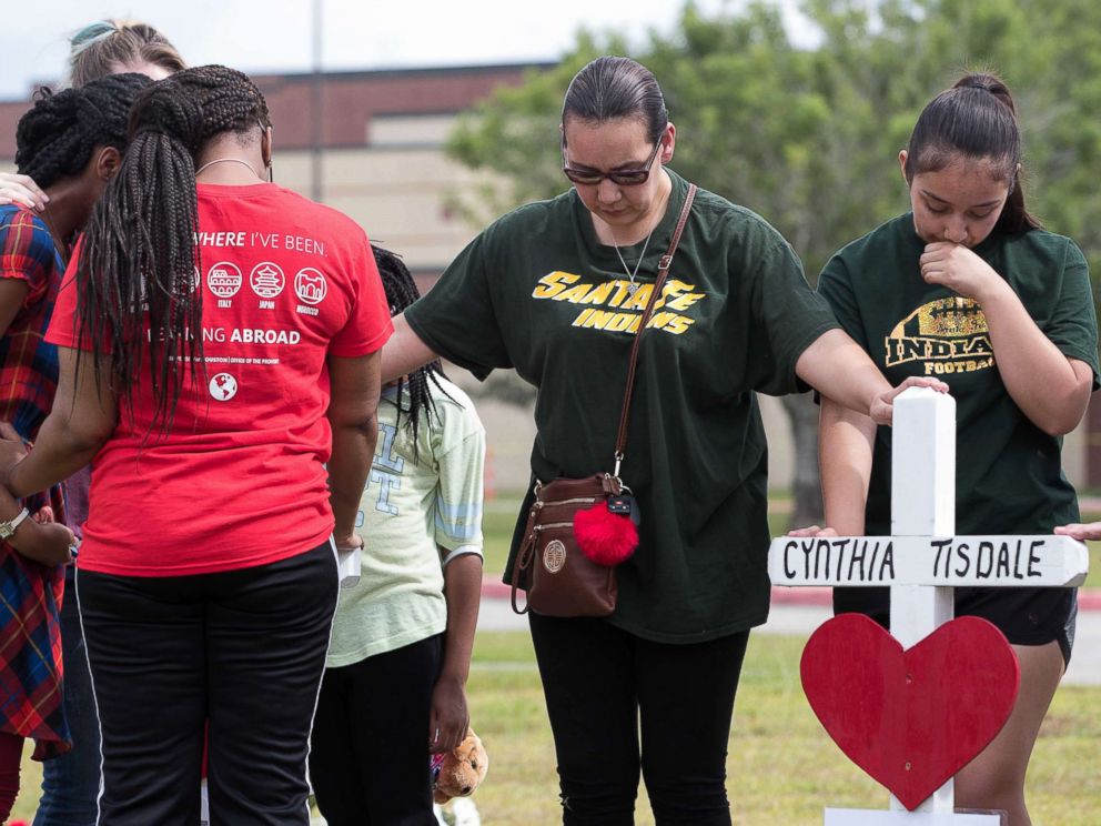 PHOTO: People place their hands on the crosses at the makeshift memorial outside Santa Fe High School during a moment of silence at 10am, May 21, 2018, in Santa Fe, Texas.