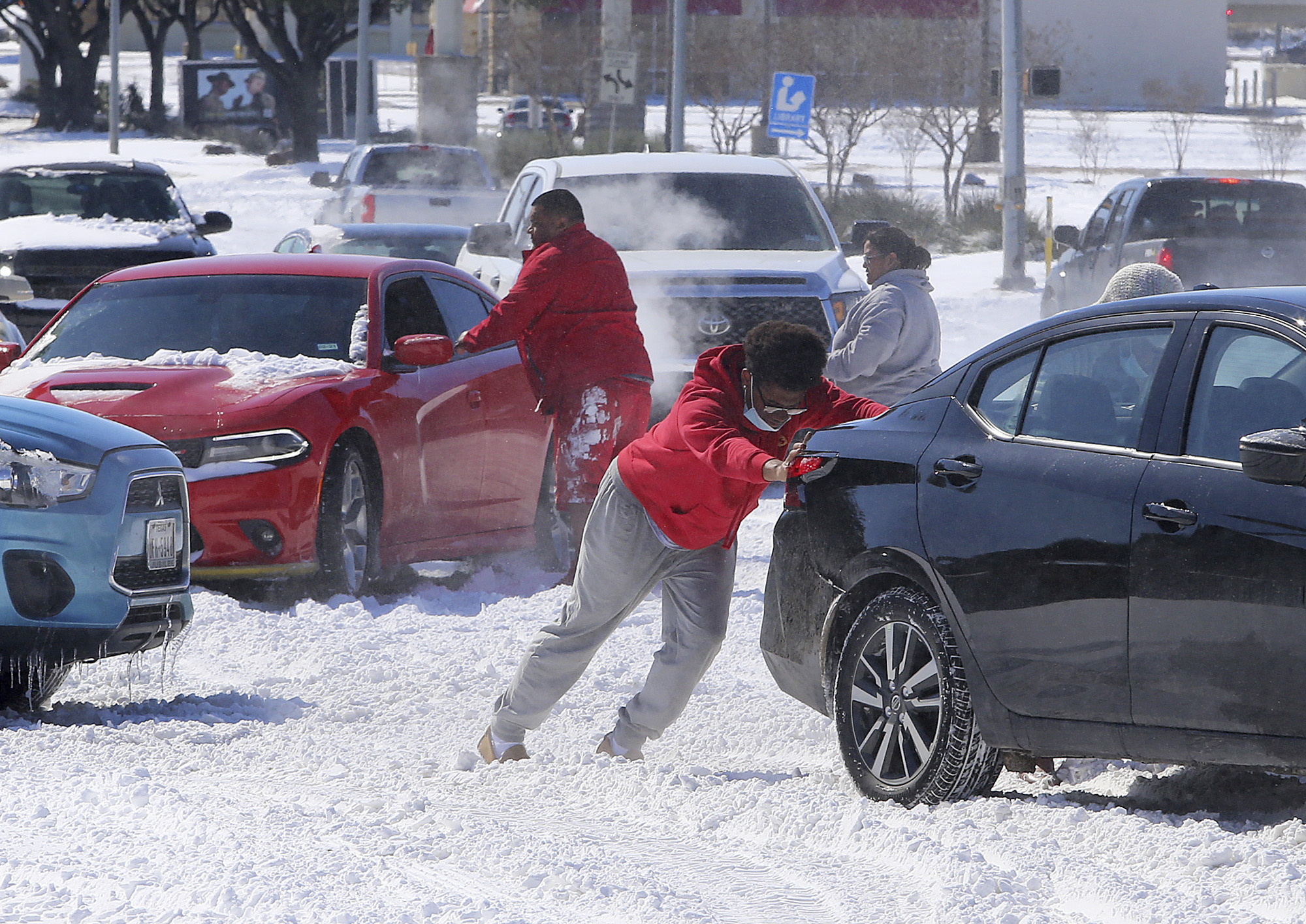 PHOTO: People push a car free after spinning out in the snow on Feb. 15, 2021, in Waco, Texas.