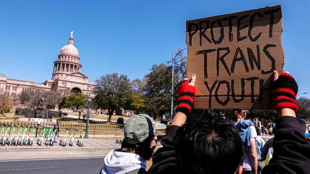 PHOTO: A protester holds up a sign as a a rally for trans rights passes in front of the Texas Capitol in Austin, Texas, on Feb. 27, 2022.
