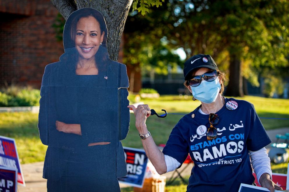 PHOTO: A person waits in line to vote near a large depicting Vice Presidential candidate Kamala Harris, outside Fretz Park Branch Dallas Public Library, on Oct. 29, 2020 in Dallas. 
