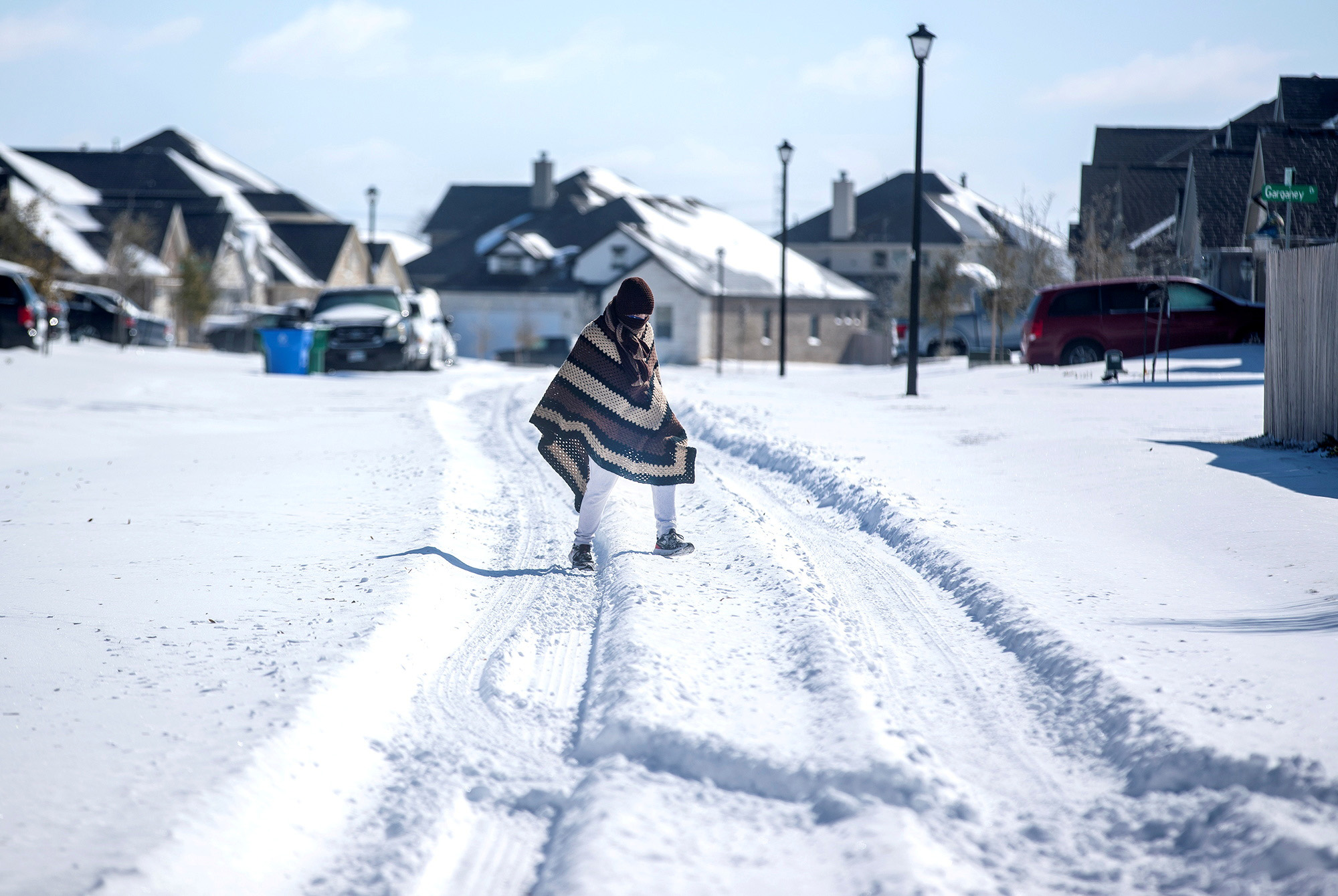 PHOTO: A man walks to his friend's home in a neighborhood without electricity in Pflugerville, Texas, Feb. 15, 2021.