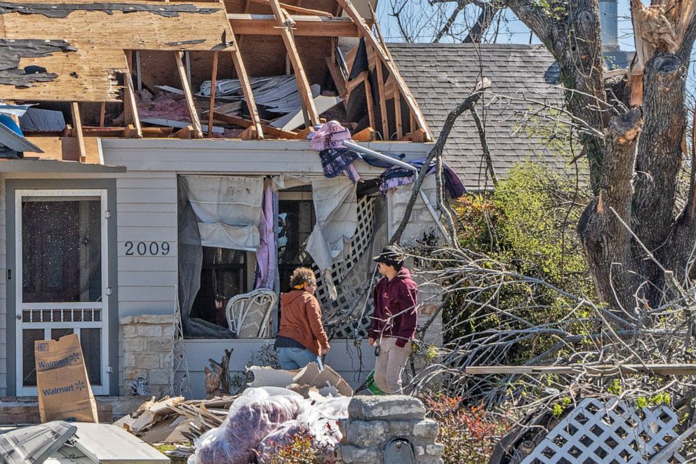 PHOTO: People look at their damaged house after tornados in Round Rock, Texas, on March 22, 2022.