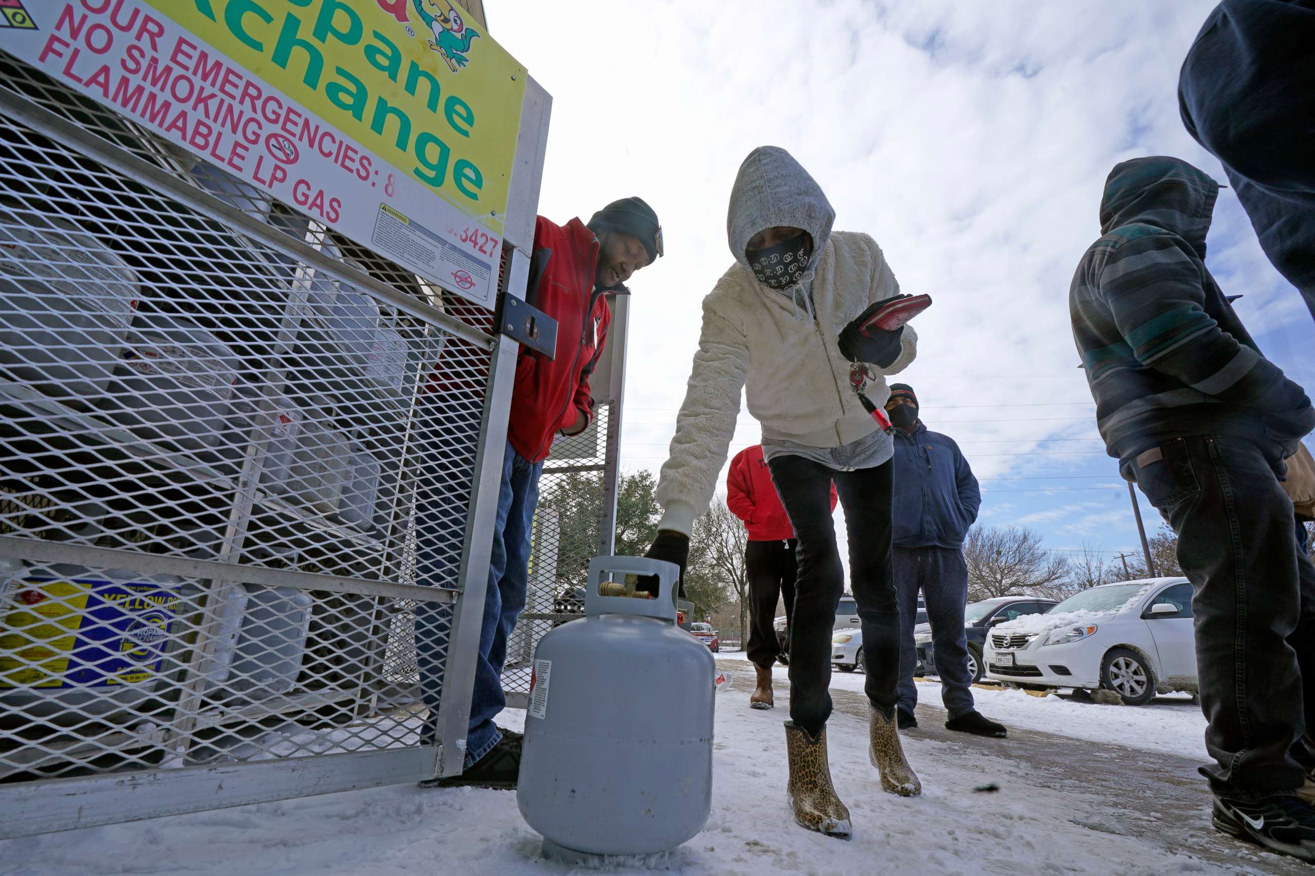PHOTO: Christine Chapman sets down an empty canister to exchange for a full propane tank outside a grocery store Feb. 16, 2021, in Dallas.