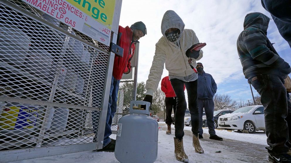 PHOTO: Christine Chapman sets down an empty canister to exchange for a full propane tank outside a grocery store Feb. 16, 2021, in Dallas.