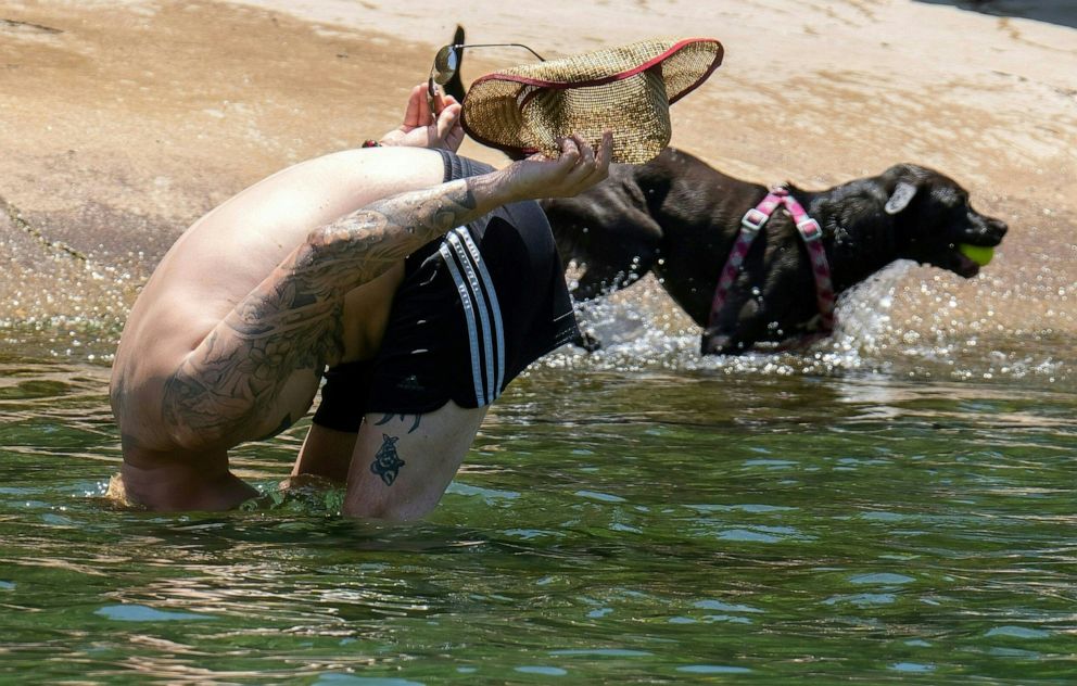 PHOTO: A man dunks his head to cool off in Barton Creek Pool on June 27, 2023 in Austin, Texas.