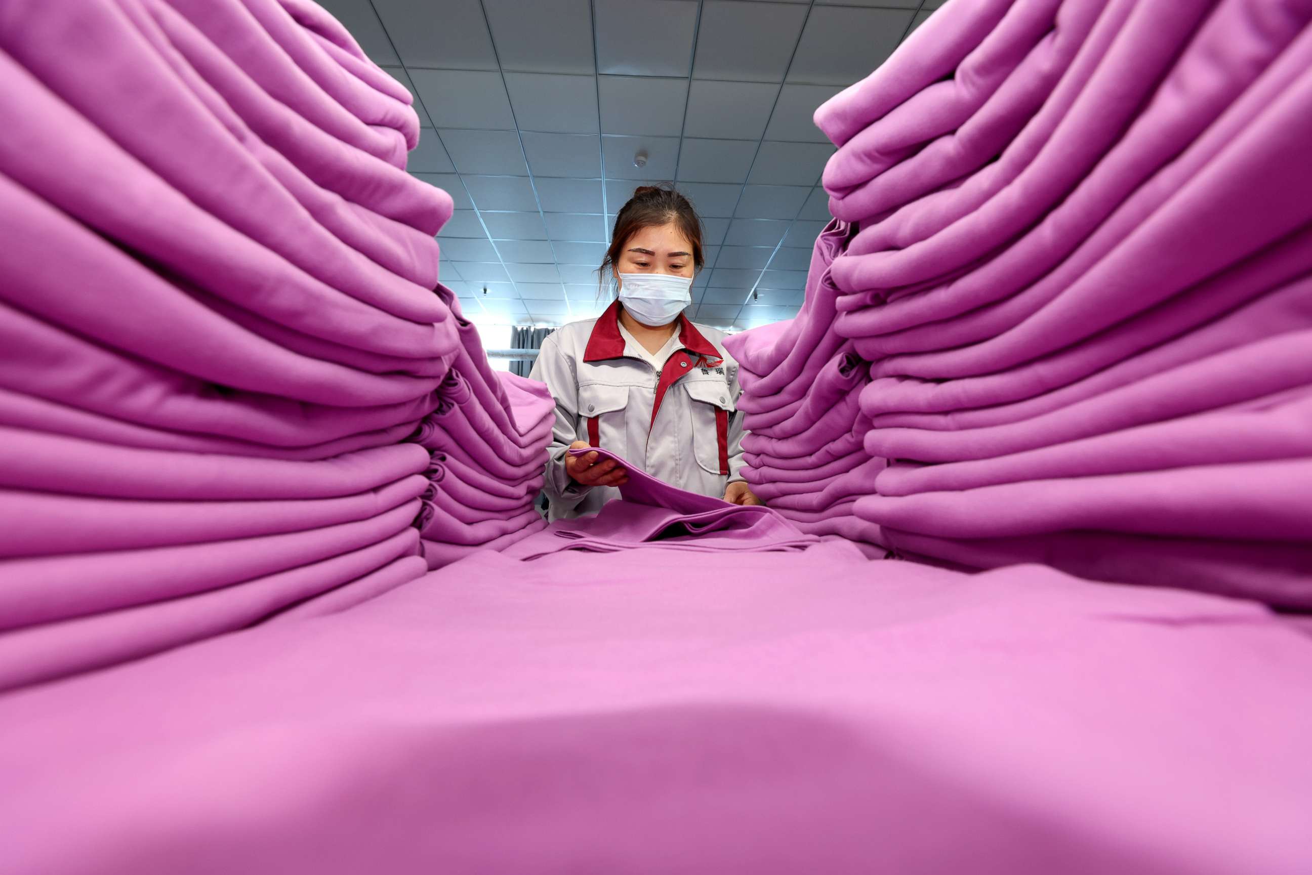 PHOTO: A worker arranges clothing products for export to overseas markets at a textile factory in Zaozhuang, China, April 17, 2022.
