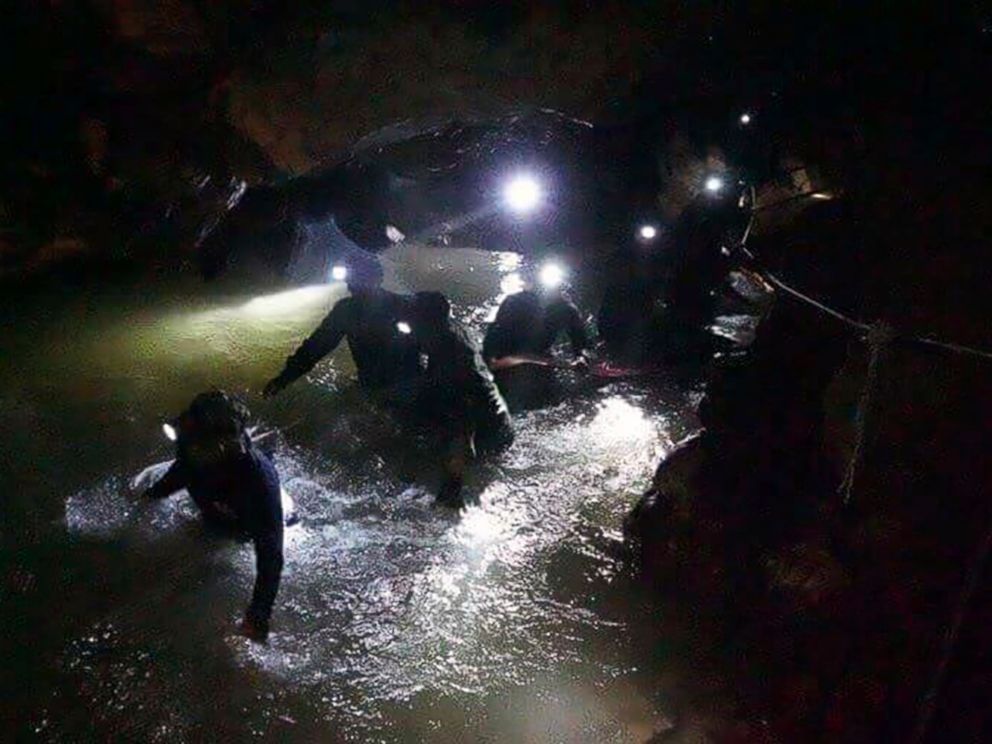   PHOTO: Thai rescue teams walk into a cave complex where 12 boys and their trainers disappeared in Mae Sai, Chiang Rai Province, northern Thailand, on July 2, 2018. 