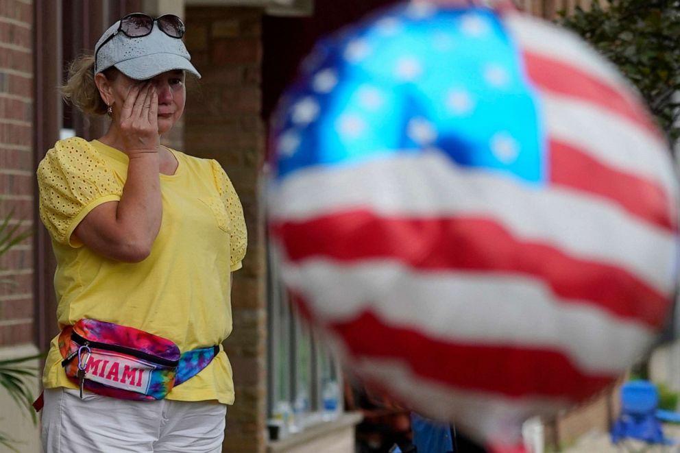 PHOTO: A woman wipes tears after a mass shooting at the Highland Park Fourth of July parade in Highland Park, Ill., a Chicago suburb, July 4, 2022. 