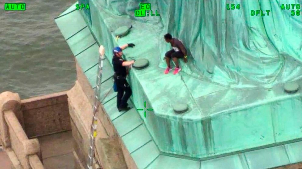 PHOTO: In an image made from video provided by the New York City Police Department, members of the NYPD Emergency Service Unit work to safely remove Therese Okoumou from the base of the Statue of Liberty, July 4, 201