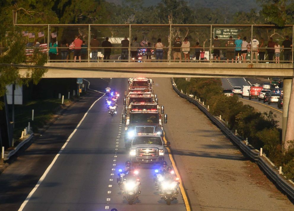 PHOTO: A funeral procession by firefighters and police was organized as people up on the freeway overpasses to pay their respects for firefighter Cory Iverson, Dec. 14, 2017. 