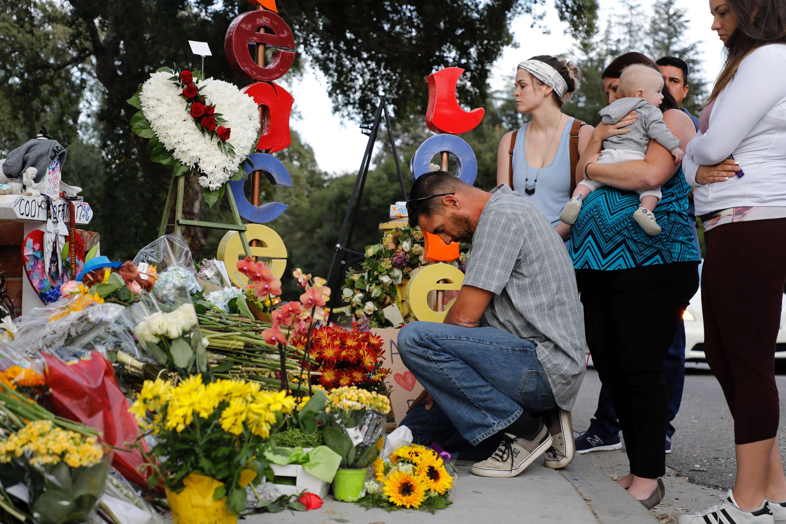 PHOTO: Jason Coffman, father of slain victim Cody Coffman, kneels at a memorial not far from where the Borderline Bar and Grill shooting happened in Thousand Oaks, Calif., Nov. 15, 2018.