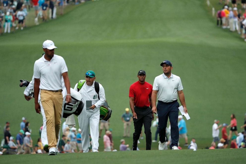 PHOTO: Francesco Molinari, Tiger Woods and Tony Finau walk up the first fairway during final round play at the Masters in Augusta, Ga., April 14, 2019. 