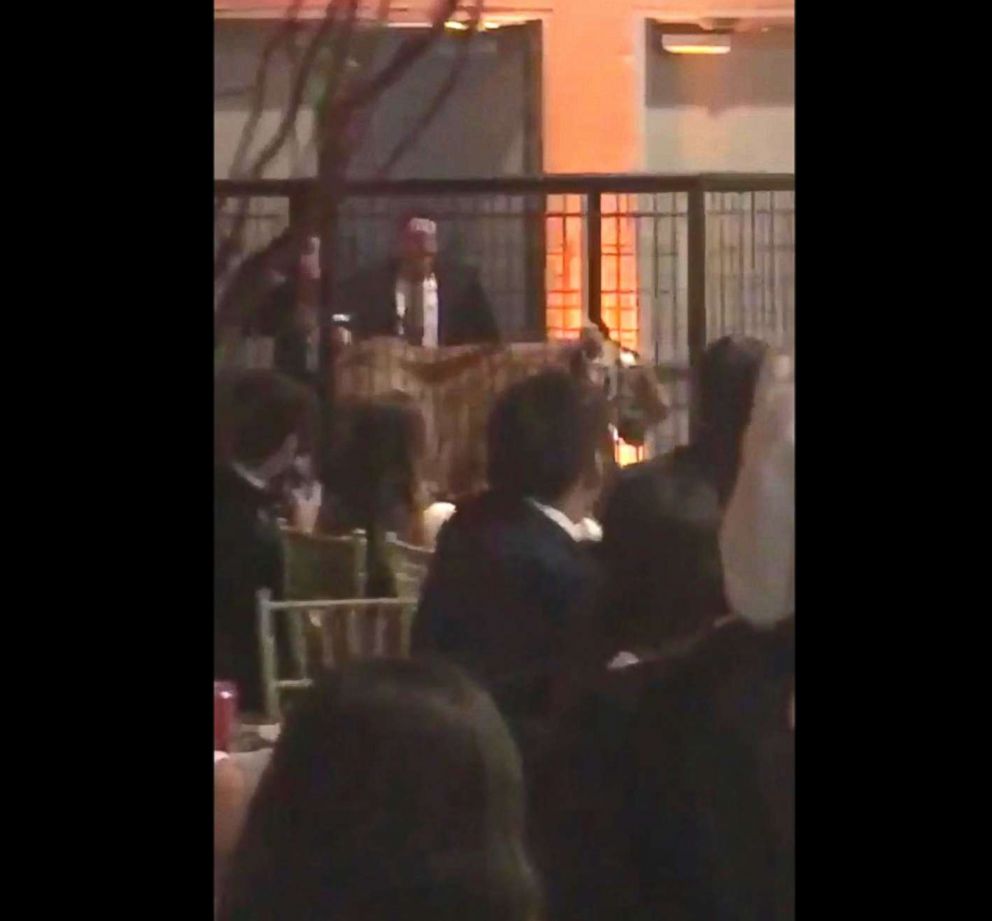 PHOTO: A handler is captured on cell phone video wheeling out a caged tiger on Friday as many Miami prom dance attendees from Christopher Columbus High School get out their cell phones to record the moment.