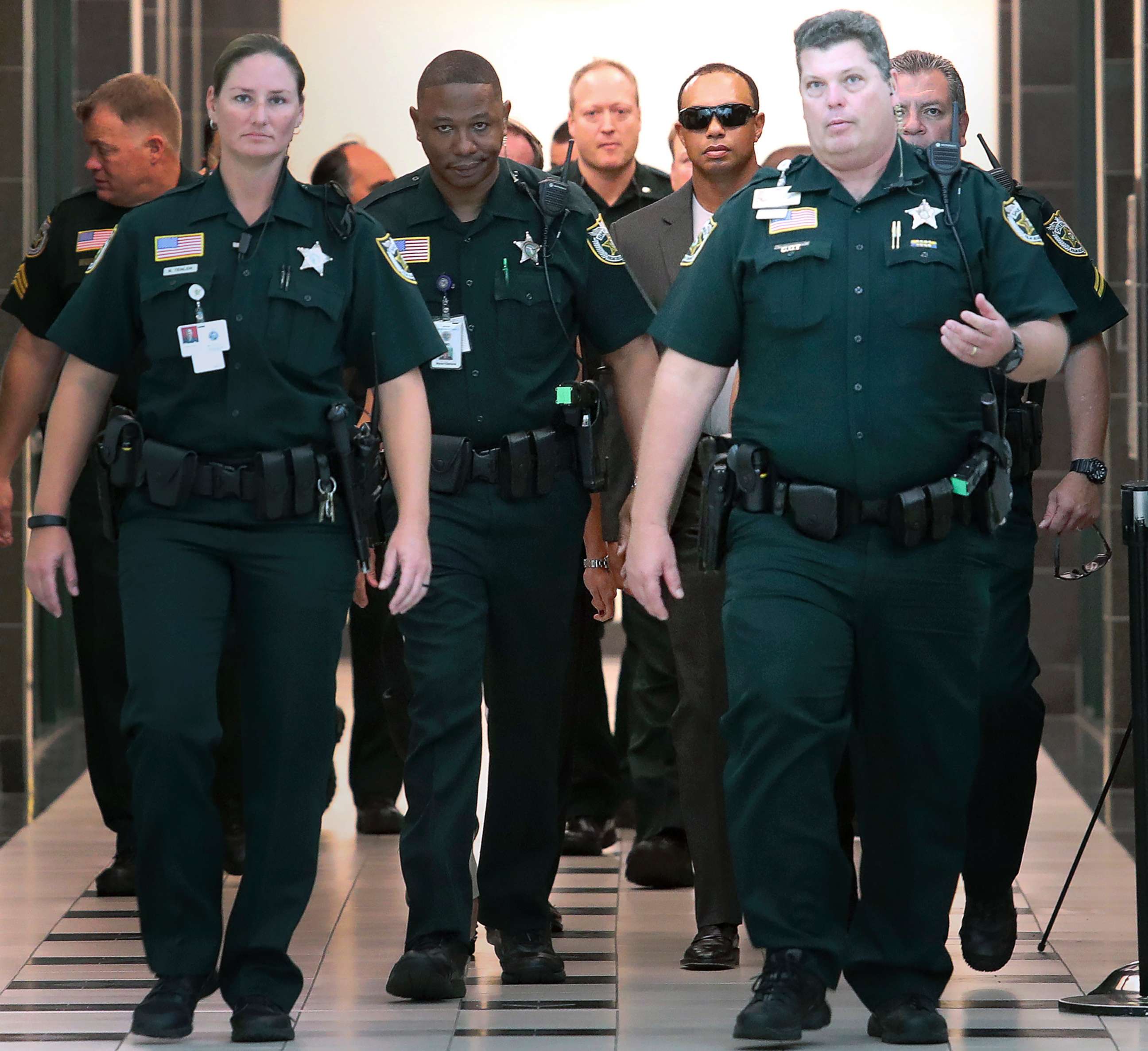 PHOTO: Tiger Woods, center right,  makes his way into a North County Courthouse courtroom in Palm Beach Gardens, Fla., Oct. 27, 2017.