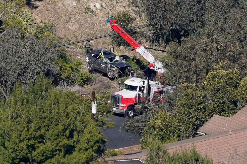 PHOTO: Workers move a vehicle after a rollover accident involving golfer Tiger Woods, Feb. 23, 2021, in the Rancho Palos Verdes section of Los Angeles.