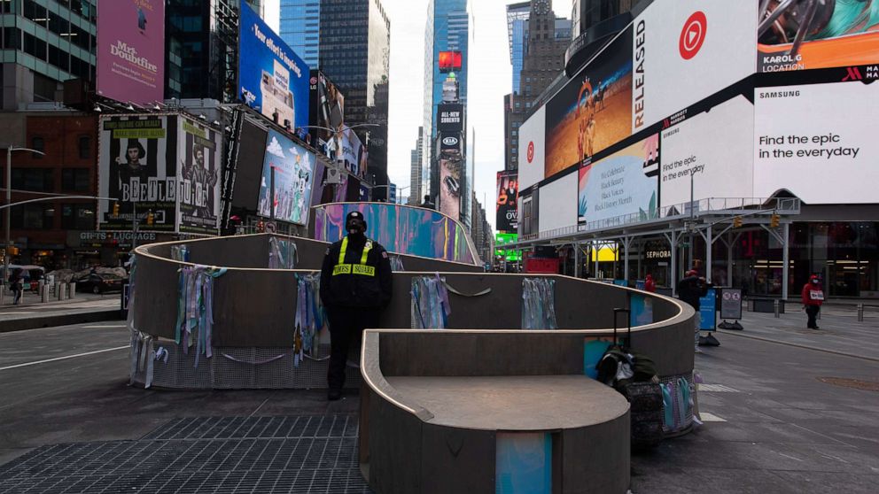 PHOTO: A security guard stands with an art installation in New York's Times Square, Feb. 16, 2021.