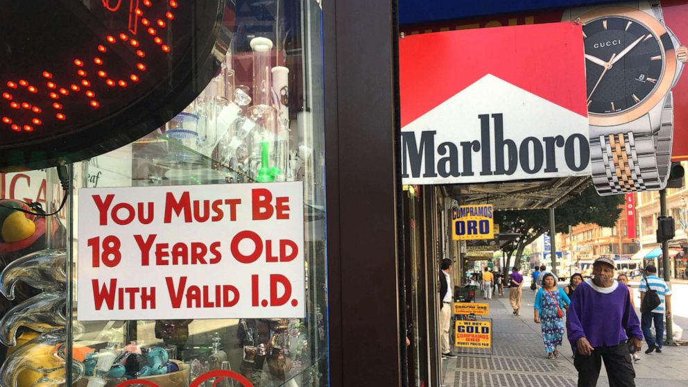 PHOTO: A sign posted outdoors at a smoke shop reads "You Must Be 18 Years Old with Valid I.D.," in downtown Los Angeles on Wednesday, June 8, 2016.
