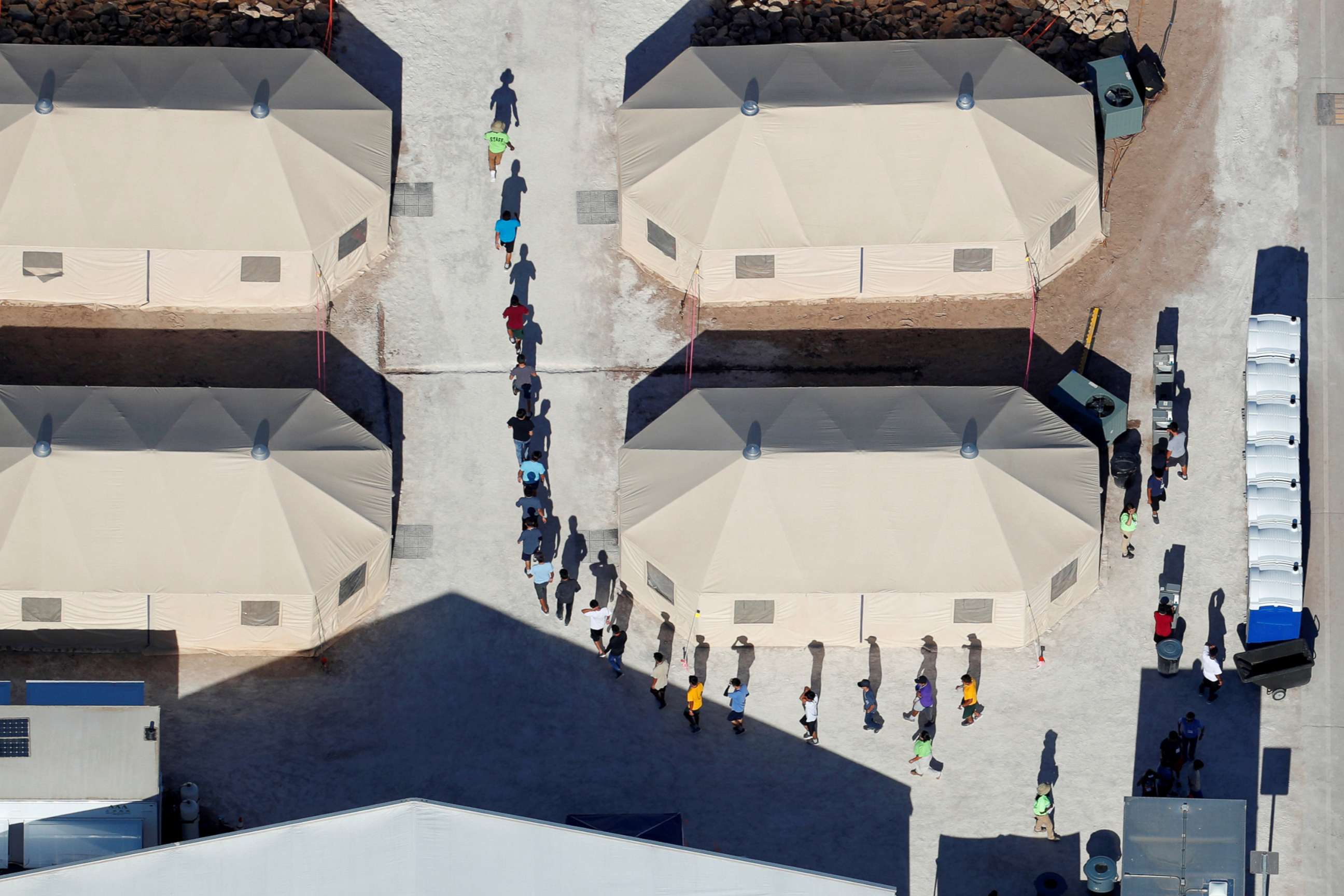 PHOTO: Immigrant children, many of whom have been separated from their parents, walk in a single file between tents in their compound next to the Mexican border in Tornillo, Texas, June 18, 2018.
