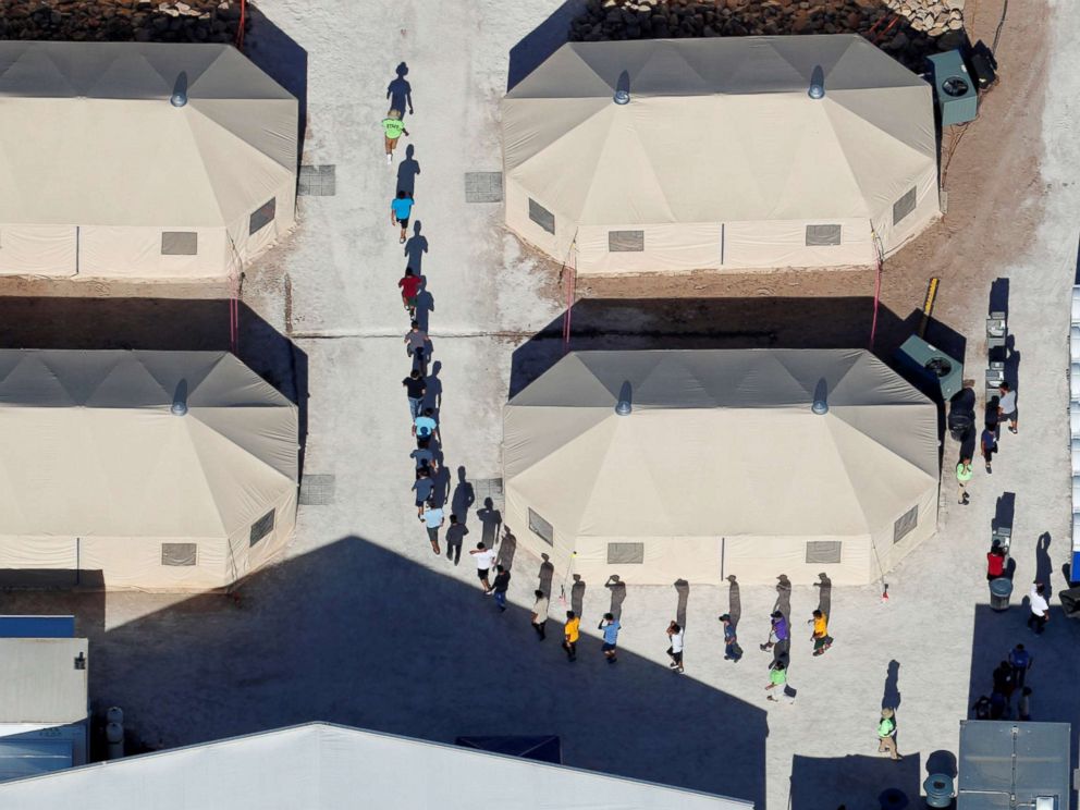 PHOTO: Immigrant children, many of whom have been separated from their parents, walk in a single file between tents in their compound next to the Mexican border in Tornillo, Texas, June 18, 2018.