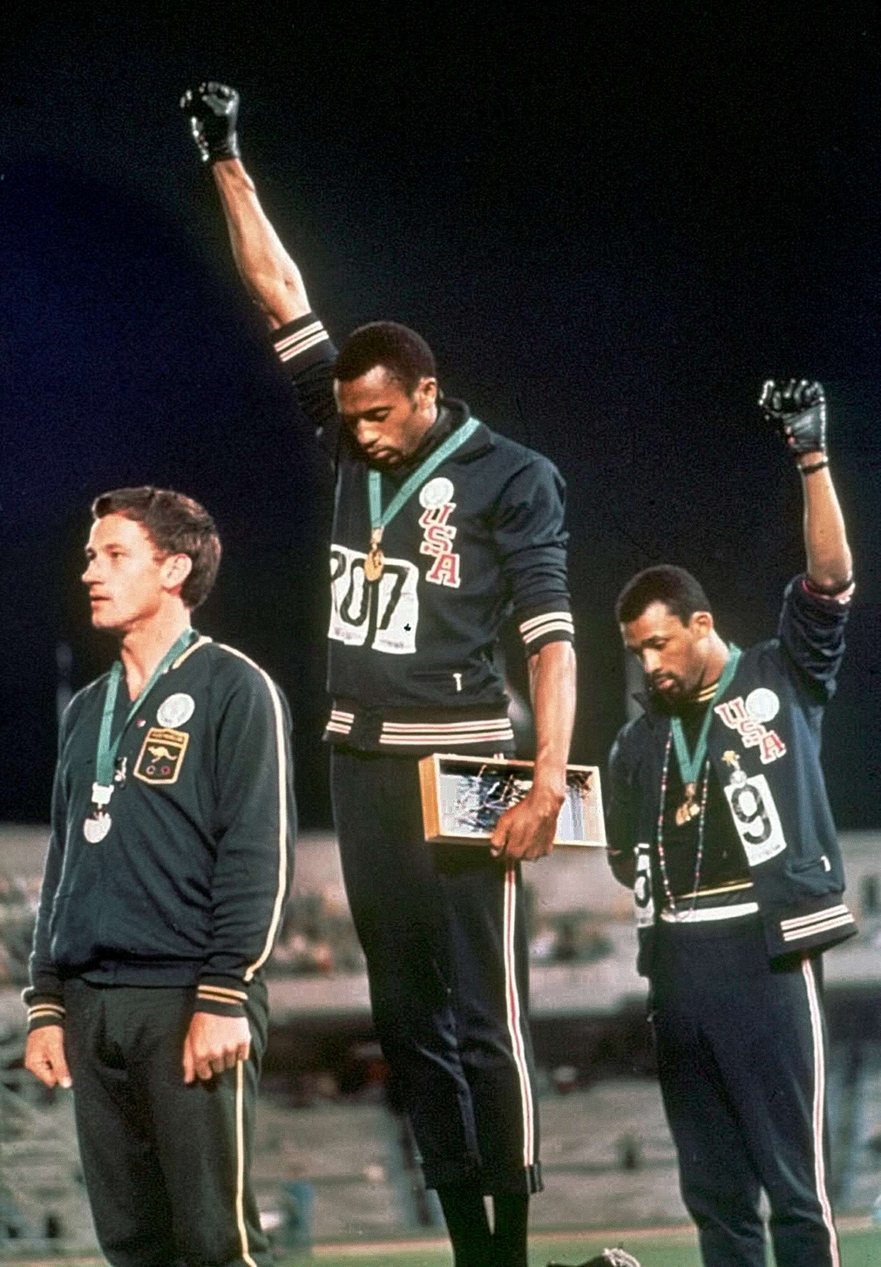 PHOTO: Athletes Tommie Smith, center, and John Carlos stare downward during the playing of "The Star-Spangled Banner" after Smith received the gold and Carlos the bronze medal in the 200 meter run at the Summer Olympic Games in Mexico City. 