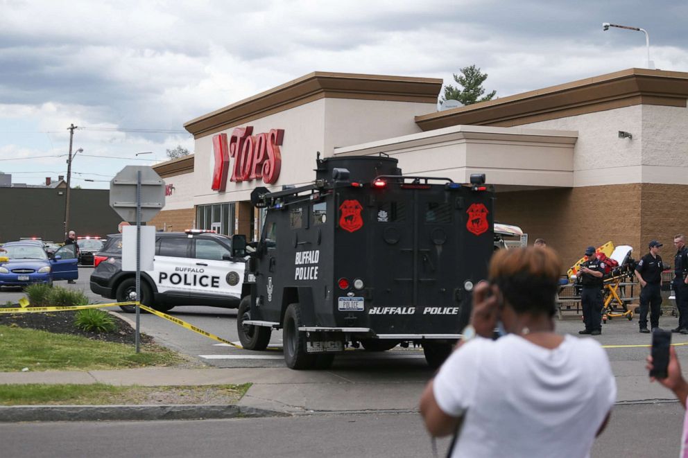 PHOTO: A crowd gathers as police investigate after a shooting at a supermarket, May 14, 2022, in Buffalo, N.Y. Multiple people were shot at the Tops Friendly Market.