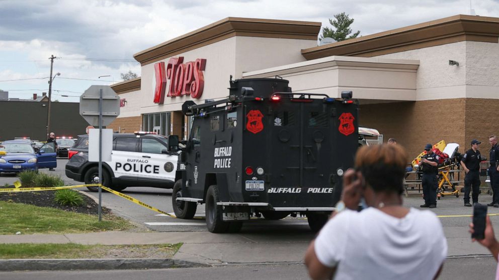 PHOTO: A crowd gathers as police investigate after a shooting at a supermarket, May 14, 2022, in Buffalo, N.Y. Multiple people were shot at the Tops Friendly Market.