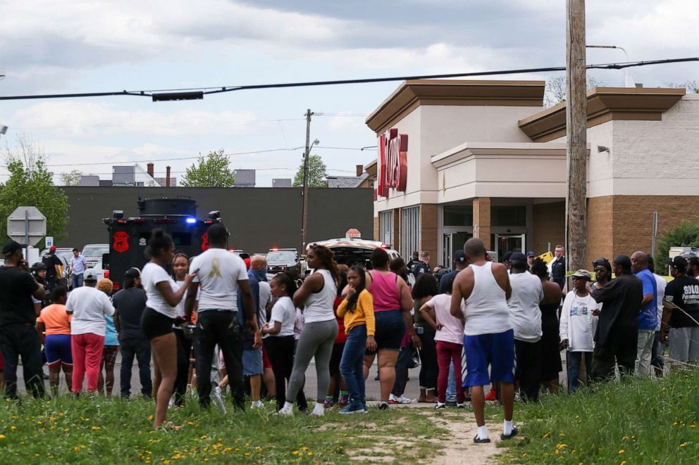 PHOTO: A crowd gathers as police investigate after a shooting at a supermarket, May 14, 2022, in Buffalo, N.Y. Multiple people were shot at the Tops Friendly Market.
