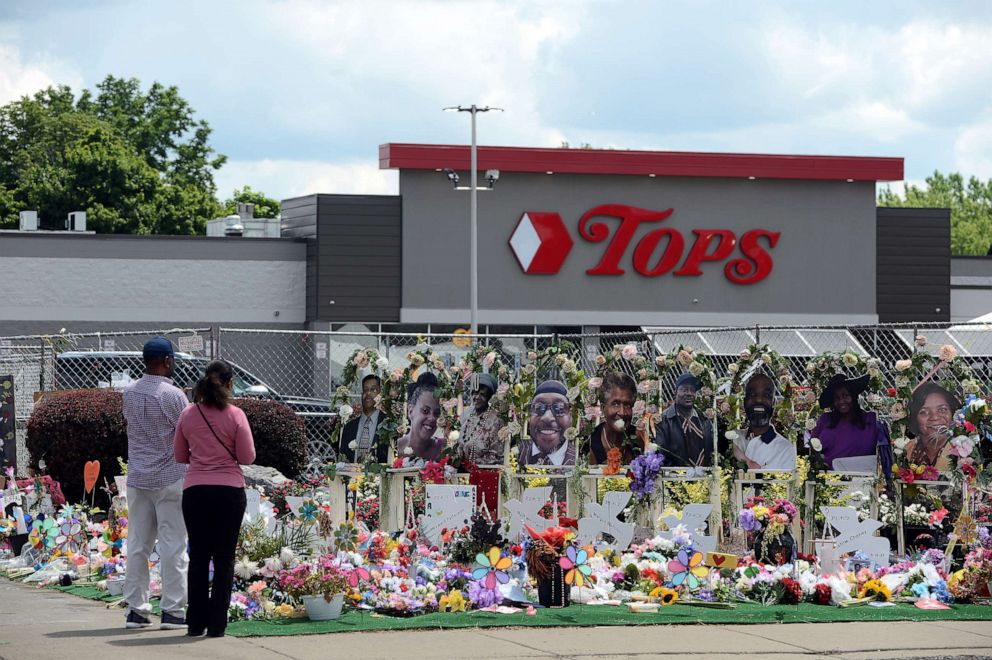 PHOTO: Community members pay respects at a "Memorial Garden" filled with flowers, photos and mementos outside the Tops Friendly Market on Jefferson Avenue, July 14, 2022, in Buffalo, N.Y.