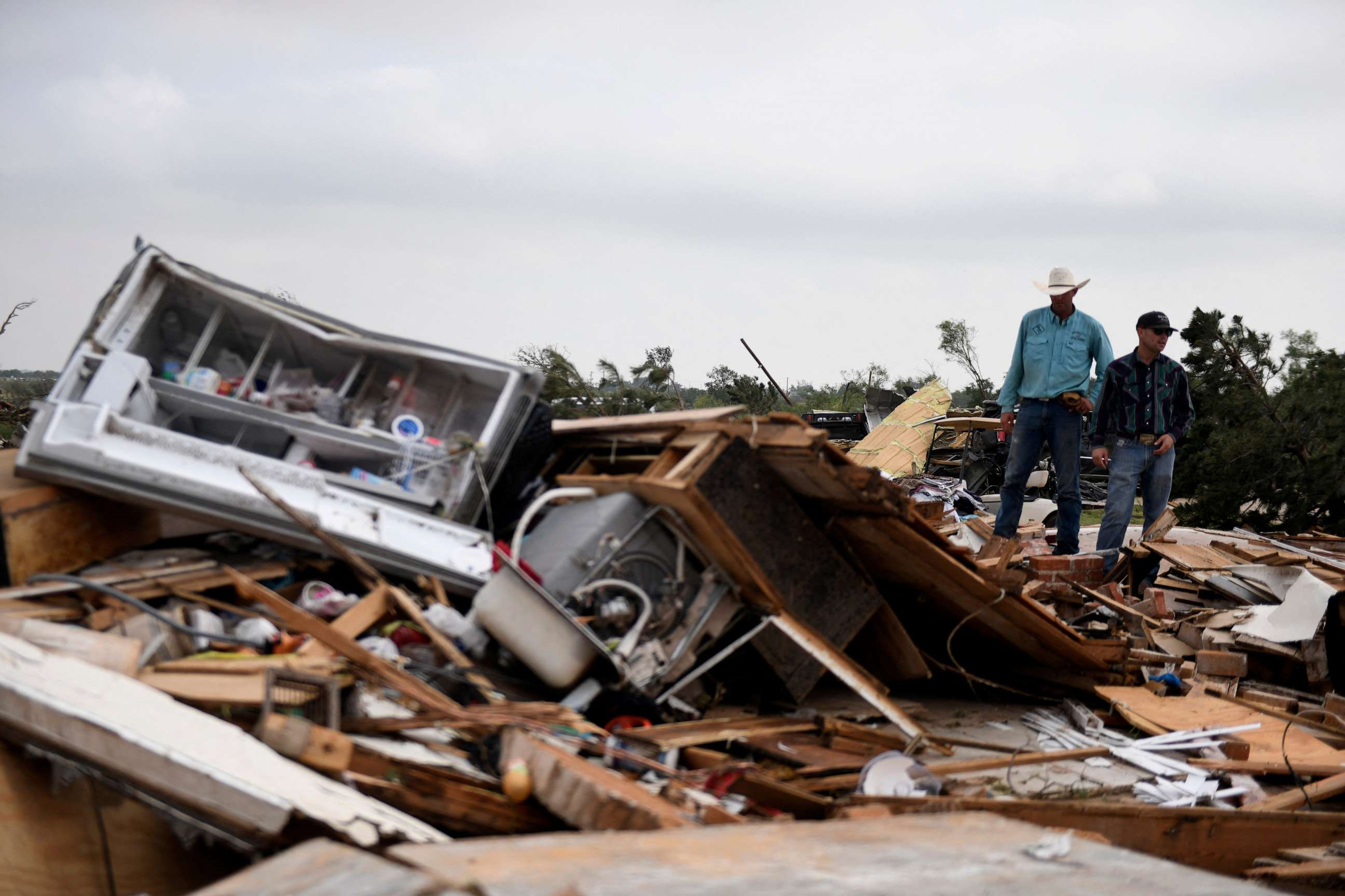 PHOTO: Residents pick up debris after a tornado hit Matador, Texas, U.S., June 22, 2023.