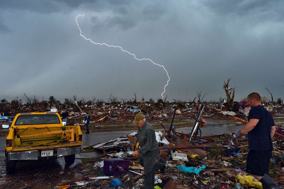 PHOTO: Lightning strikes during a thunder storm as tornado survivors search for salvagable belongings at their devastated home on May 23, 2013, in Moore, Okla.