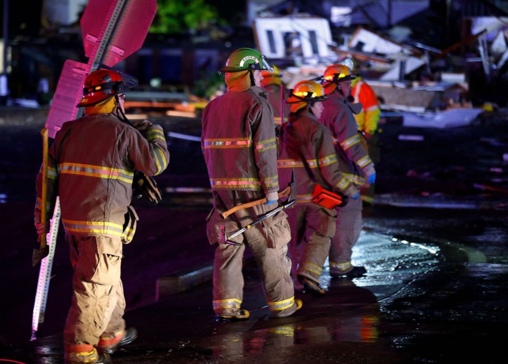 PHOTO: Firefighters walk to an area of debris from a hotel and a mobile home park in El Reno, Okla., May 26, 2019, following a tornado. 