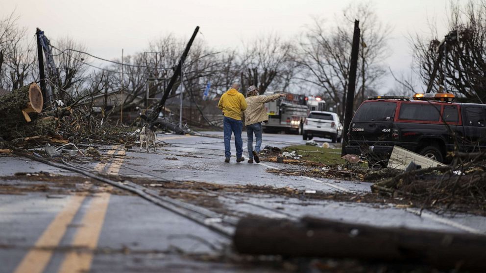 PHOTO: Residents walk through downed utility lines and trees to survey damage caused by one of several tornadoes that tore through the state overnight, March 3, 2020, in Cookeville, Tenn.