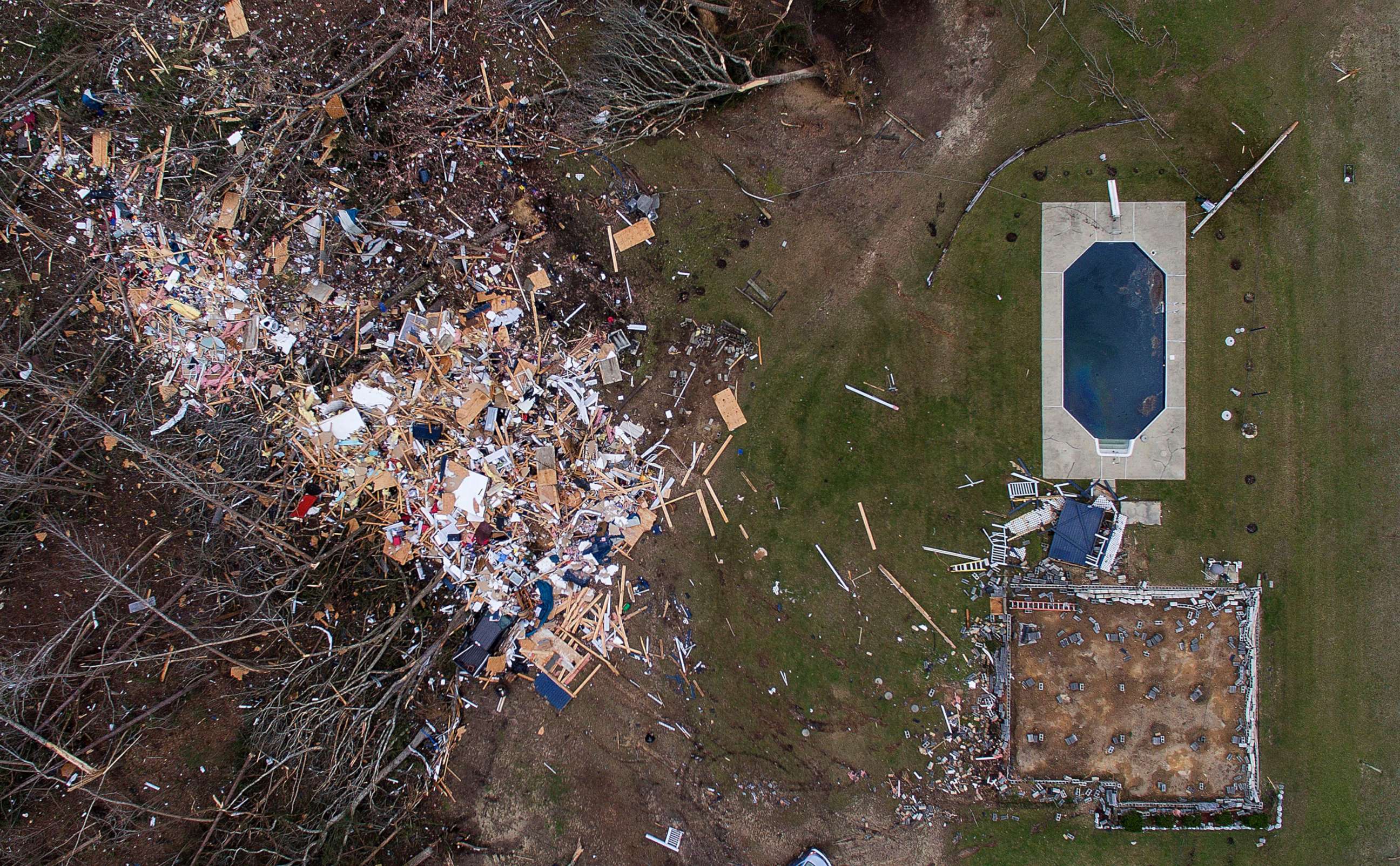 PHOTO: Debris from a home litters a yard the day after a tornado blew the building off its foundation, lower right, in Beauregard, Ala., March 4, 2019.