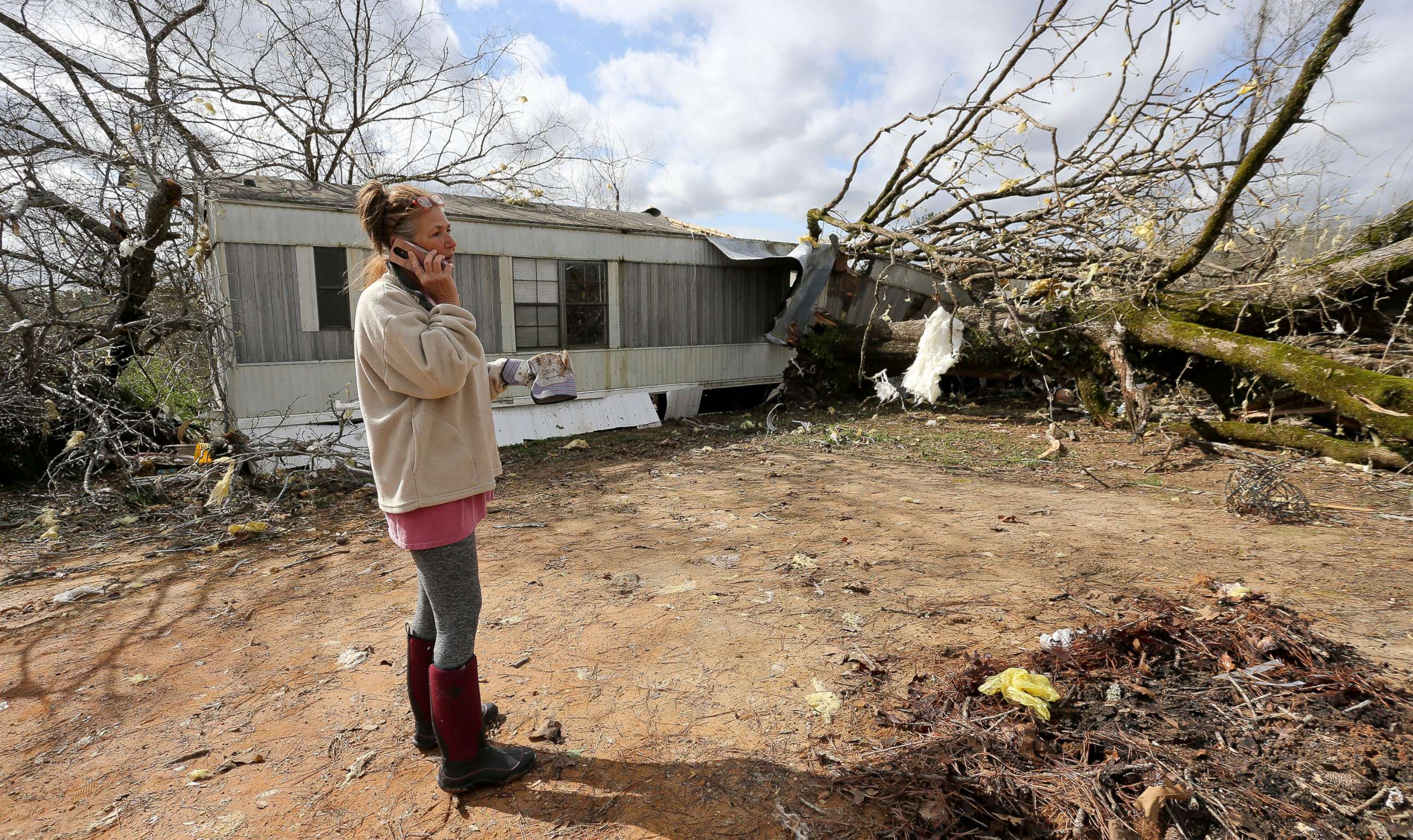 PHOTO: Jennifer Patterson talks on her cell phone outside her destroyed mobile home in Tuscaloosa County, Alabama, March 18, 2021.
