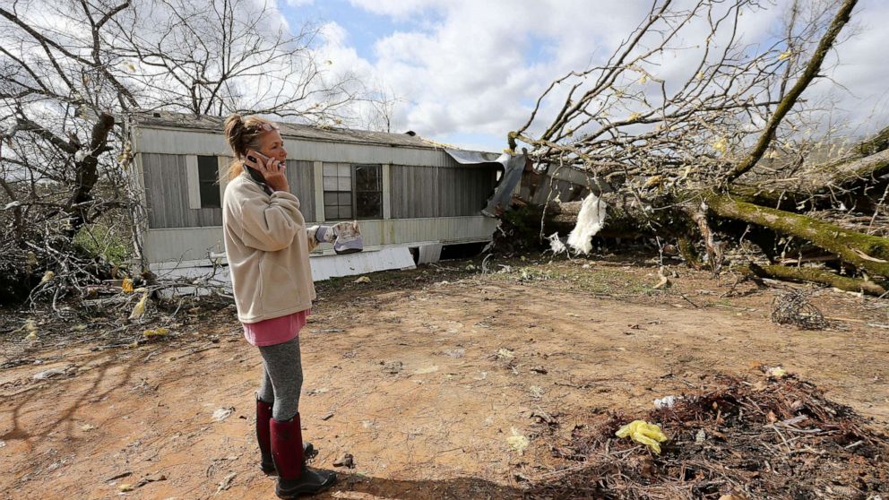 PHOTO: Jennifer Patterson talks on her cell phone outside her destroyed mobile home in Tuscaloosa County, Alabama, March 18, 2021.