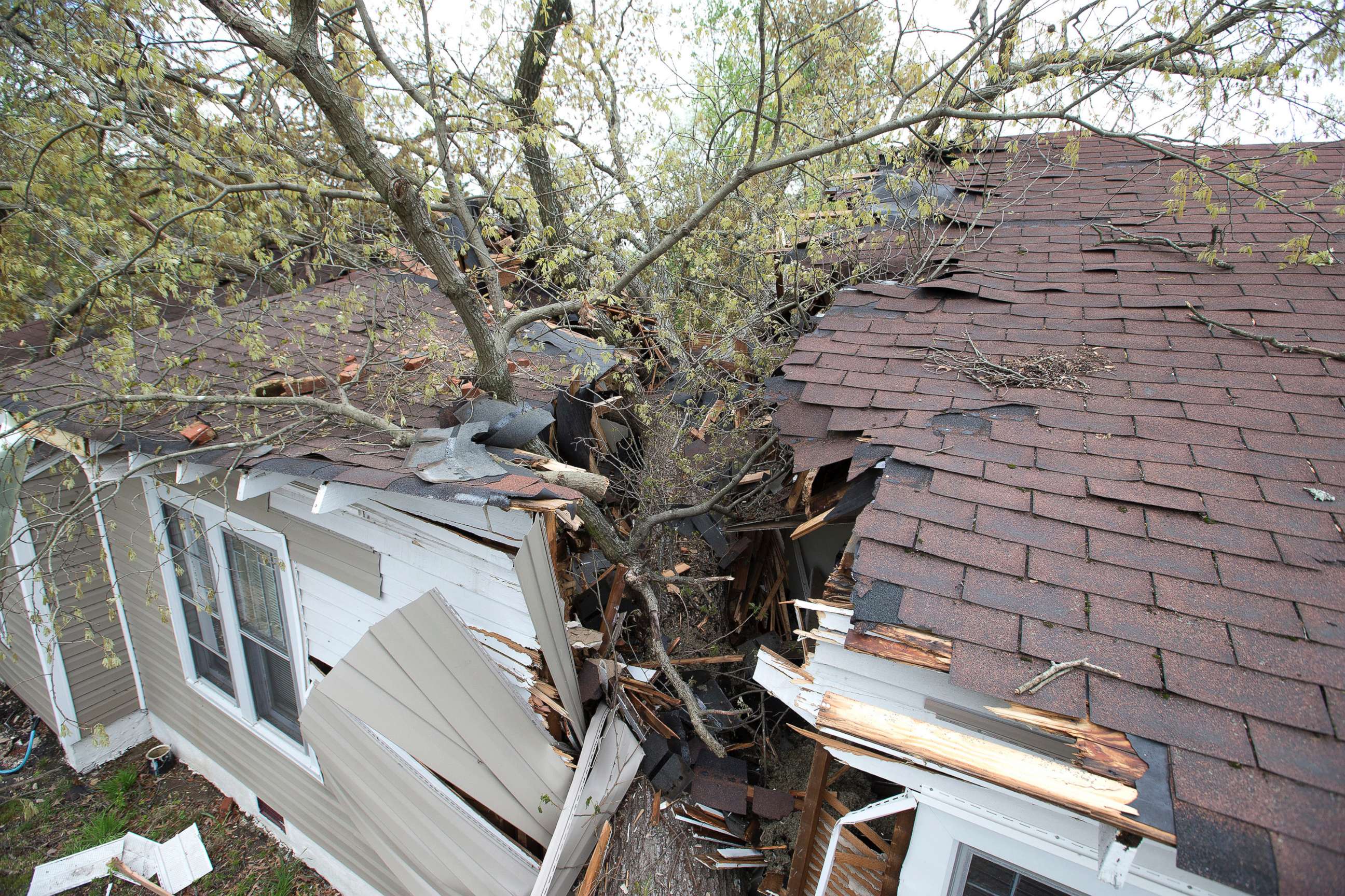 PHOTO: A tree cleaves the house on Oak Grove Avenue the day after a tornado hit, killing one person and leaving devastation throughout eastern portion of the city, April 16, 2018, in Greensboro, N.C. 