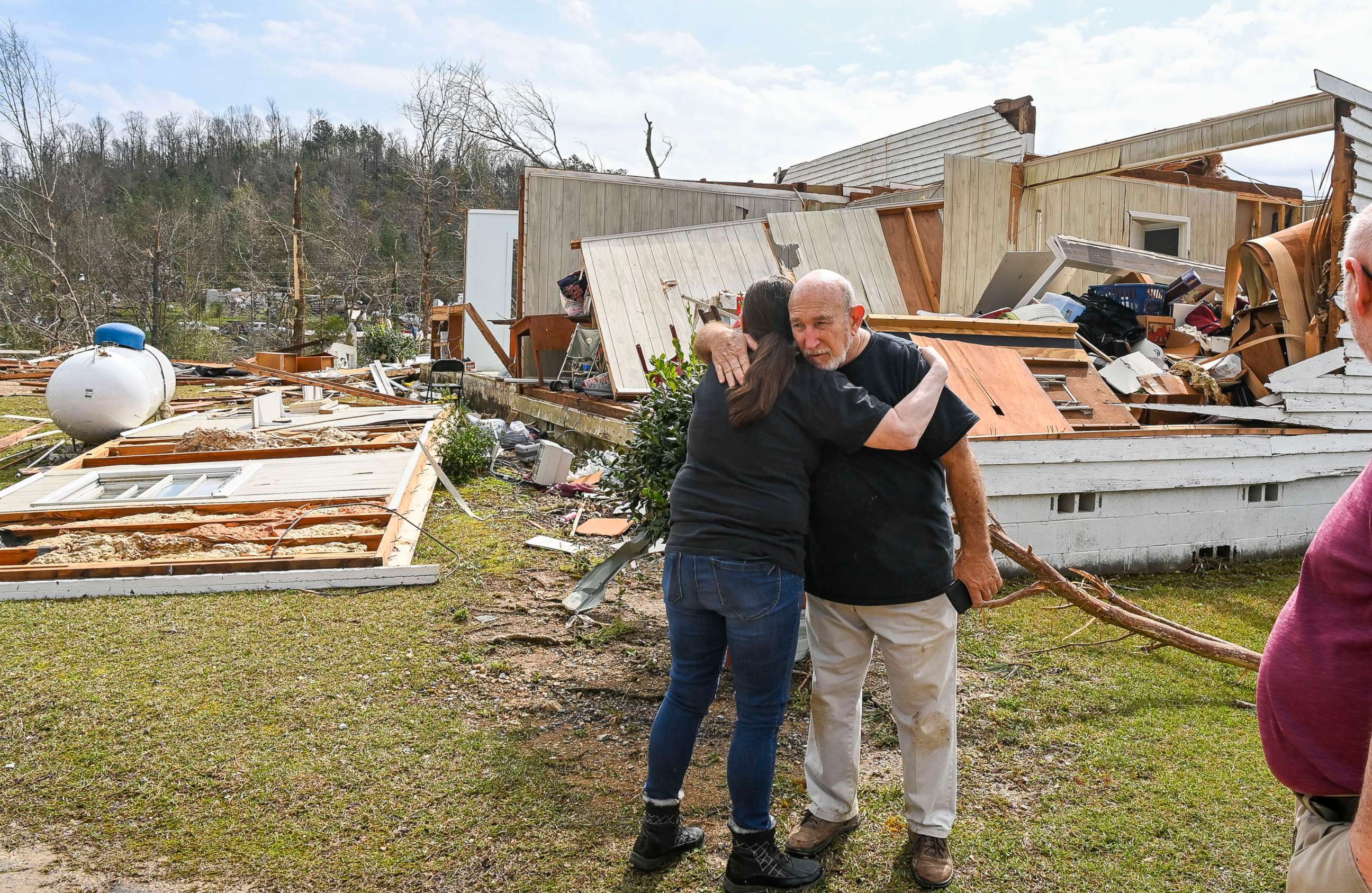 PHOTO: A neighbor hugs Danny Poss, pastor of Ragan Chapel United Methodist Church, as he surveys tornado damage at the church, on March 26, 2021, in Ohatchee, Ala.