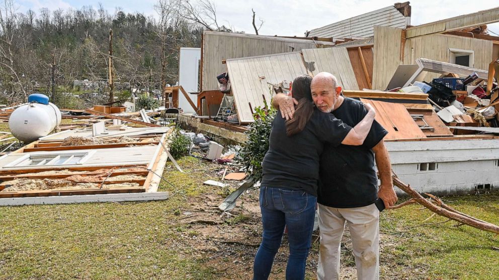 PHOTO: A neighbor hugs Danny Poss, pastor of Ragan Chapel United Methodist Church, as he surveys tornado damage at the church, on March 26, 2021, in Ohatchee, Ala.