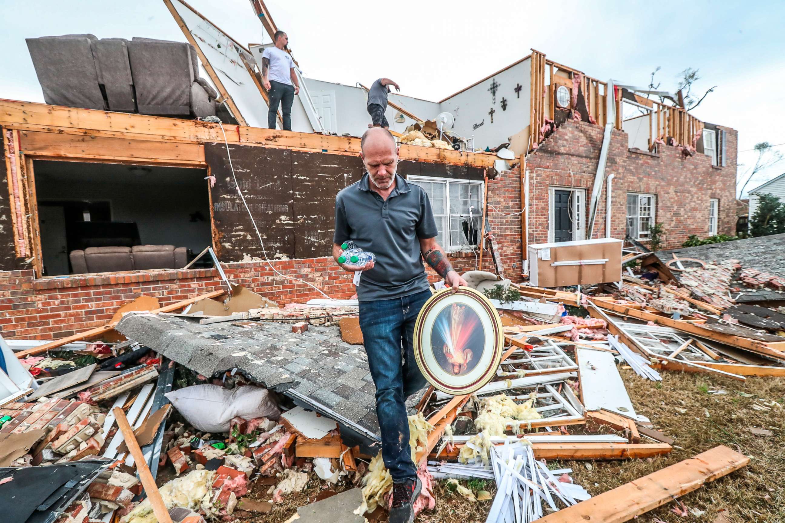 PHOTO: A man moves personal items from a home, in Newnan, in Coweta County, Ga. on March 26, 2021, after a tornado moved through the area.