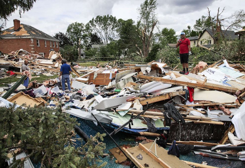 PHOTO: People search for belongings and clean up after a tornado hit in a neighborhood in Naperville, Il., June 21, 2021.