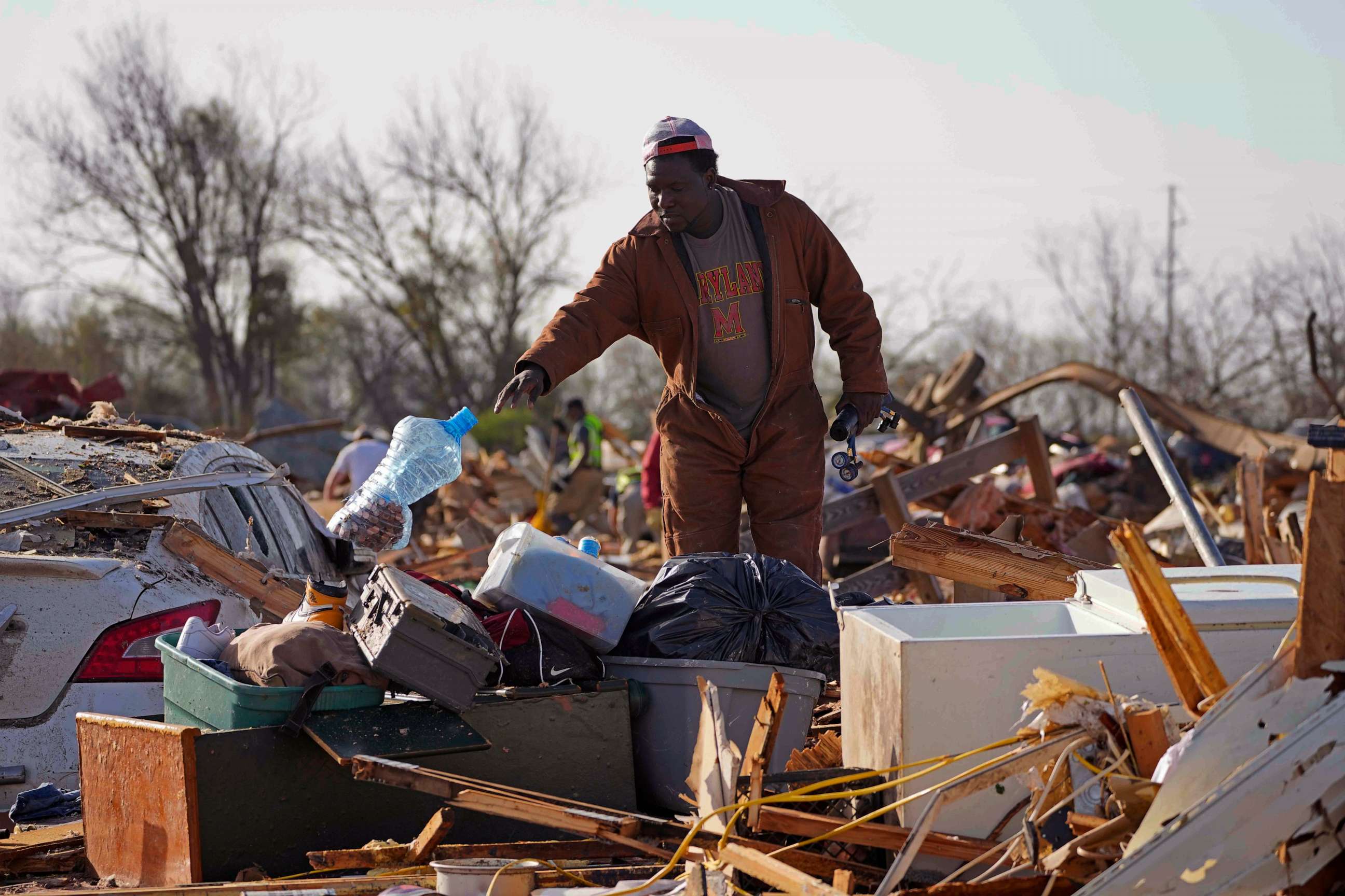 PHOTO: A resident looks through the piles of debris, insulation, and home furnishings to see if anything is salvageable at a mobile home park in Rolling Fork, Miss., Mar. 25, 2023.