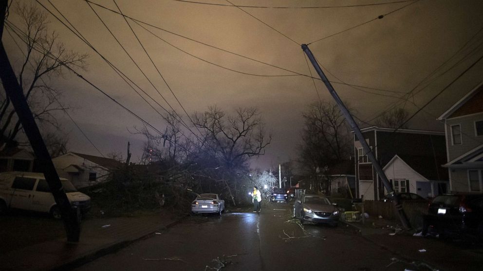 PHOTO: A resident makes her way down Underwood St. amidst downed trees and heavy debris on March 3, 2020 in Nashville, Tenn. A tornado passed through Nashville just after midnight leaving a wake of damage.