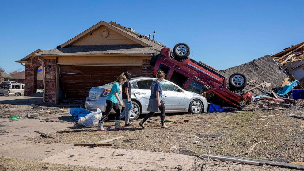 PHOTO: Neighbors walk in front of a home damaged at Wheatland Drive and Conway Drive, Feb. 27, 2023 in Norman, Okla.