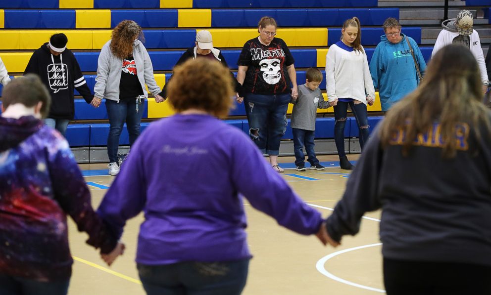 PHOTO: Students, teachers and residents hold a prayer circle in the gymnasium of Beauregard High School for those in their community that lost their lives in a Sunday night tornado on Monday, March 4, 2019, in Beauregard, Ala.