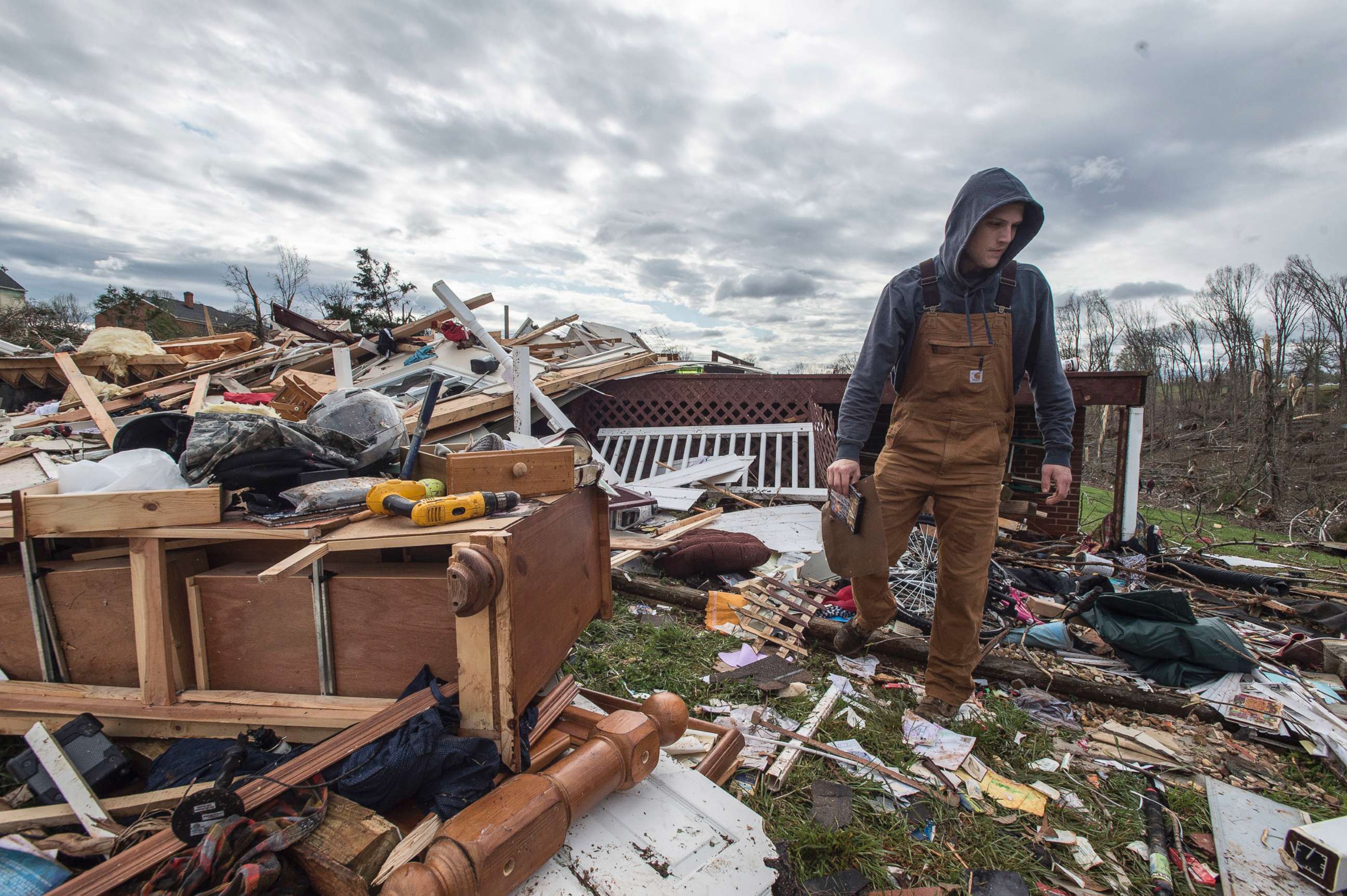 PHOTO: Ryan Polaski sorts through debris of his father-in-law's house after severe weather, April 16, 2018 in Elon, Va. 